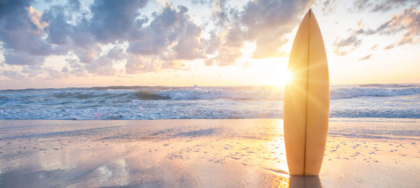 Surfboard on the beach at sunset